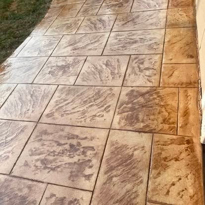 Decorative stamped concrete patio — large stone tile pattern in warm amber and tan tones